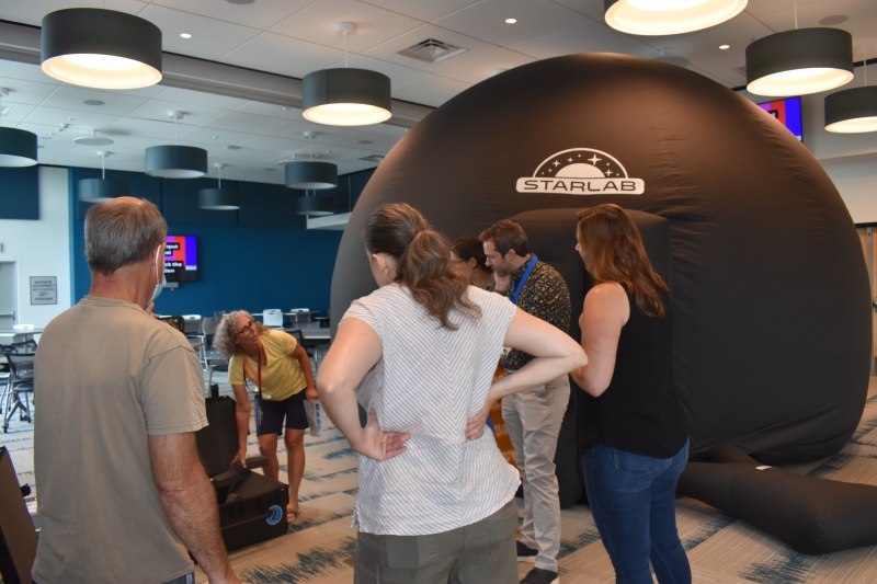 science teachers and librarians learn about setting up Starlab equipment outside blow up planetarium