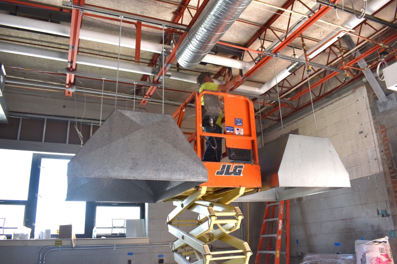 Contractors work on the HVAC system in the new print shop.