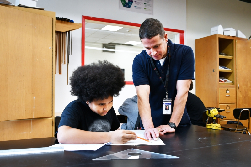 Teacher Kevin Yahn and Antonio Elmandson (Poughkeepsie) discuss a design project.