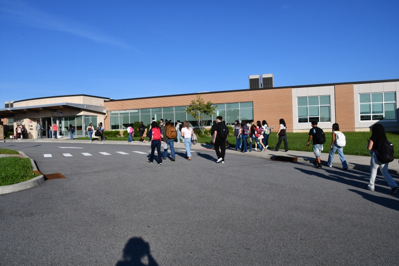 A group of students walk from buses toward the Career and Technical Institute/Resilience Academy main entrance on the first day of school, Sept . 8, 2026