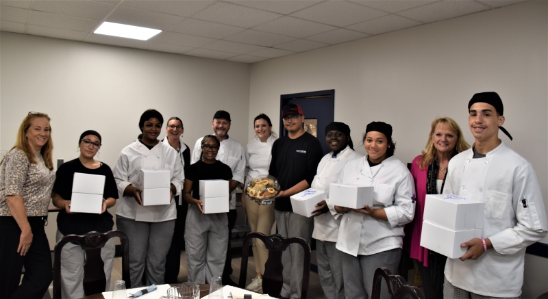 Students in the CUlinary Arts and Restaurant Management program at CTI present cookies they baked for the Board of Trustees to District Superintendent Jodi DeLucia, Board Clerk Nancy Melilli and Assistant Superintendent of Educational Services Denise Dzikowski