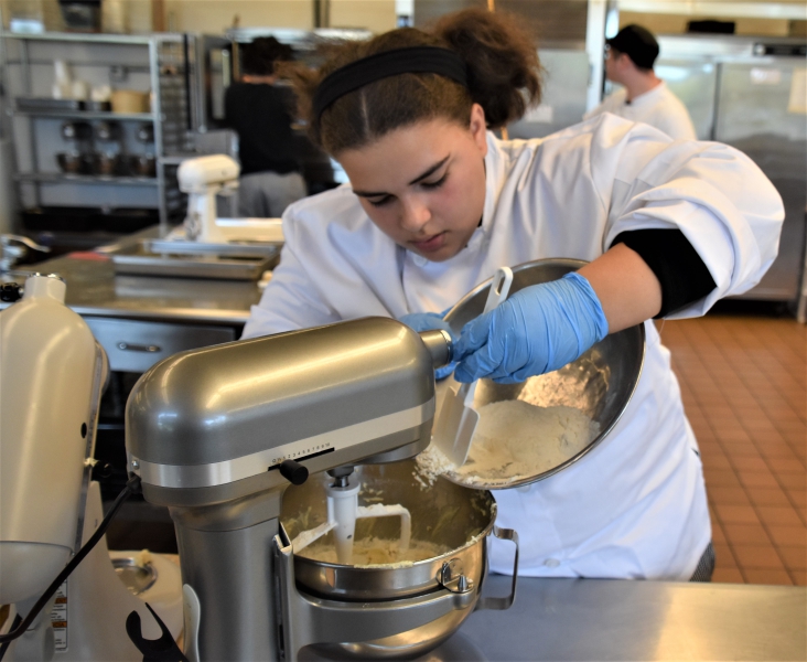 A student mixes ingredients for a fresh batch of cookies.