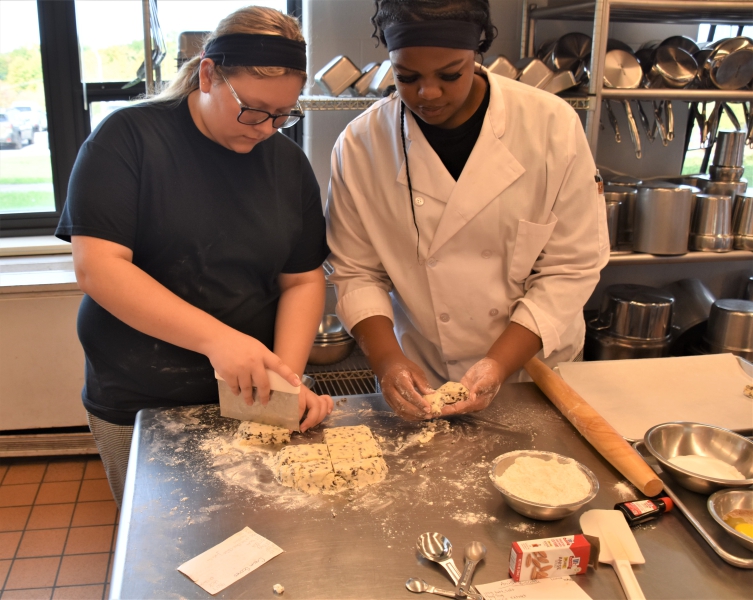 Students form and cut dough to make scones.