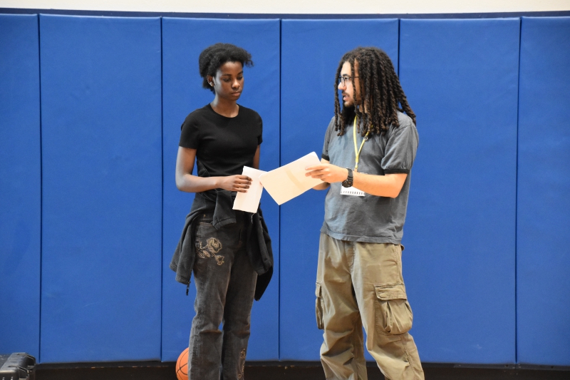 Fayza Sekatawa reviews her Escape the Vape commercial script with a member of the production crew inside the Resilience Academy gym.