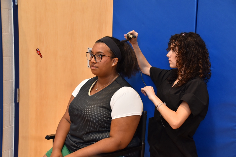 Cosmetology student Aliyah Diaz does a cast member's hair for the commercial.