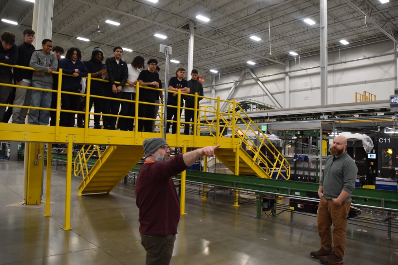 GAP's Learning Development Associate Manager David Perez speaks with P-TECH students about the work that goes on in the distribution center's packing department.