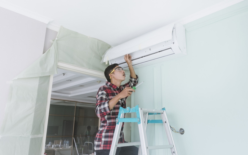 A technician repairs a mini split air conditioner