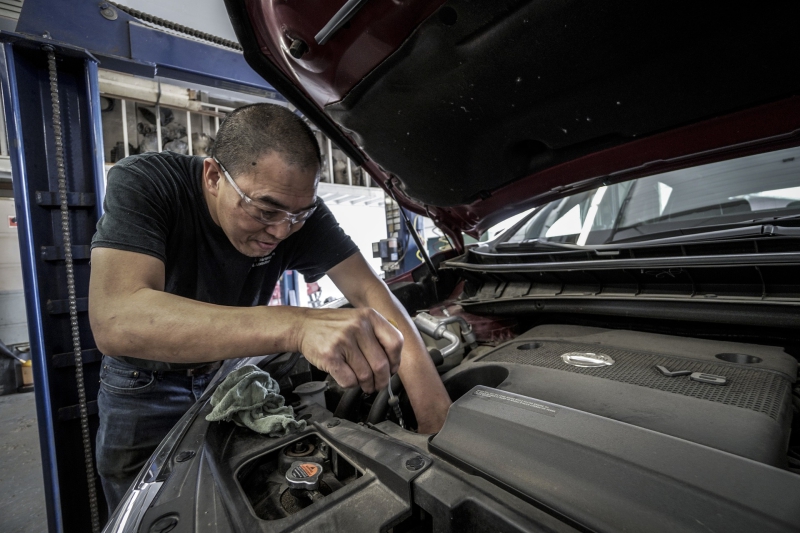 Man performing oil change on a car