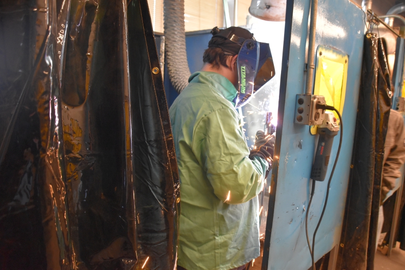 Sparks fly as an ALI student welds in one of the booths available to the class.