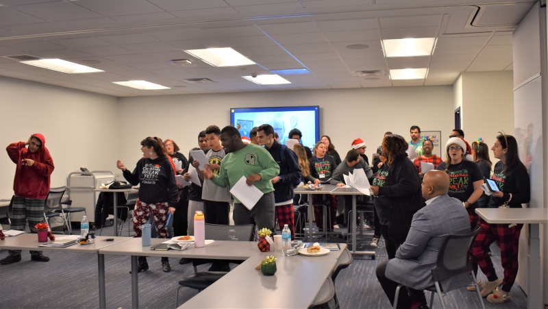 Music teacher Angela Crisci leads carolers from the Resilience Academy in song during a superintendents' meeting in the Dutchess BOCES conference center.