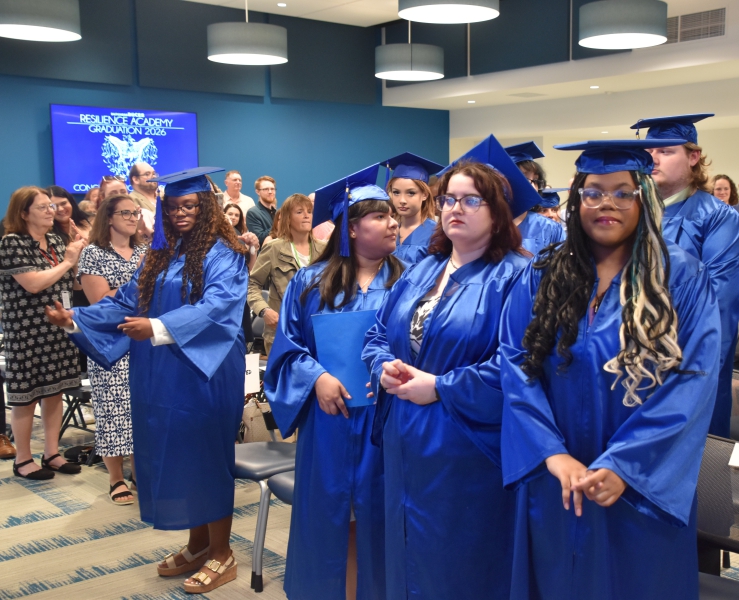 Resilience Academy Class of 2026 graduates wait for the rest of the processional before taking their seats