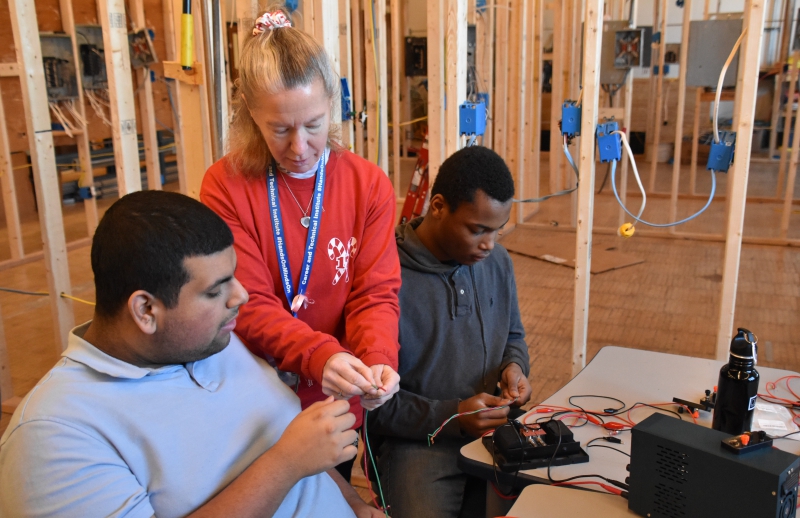 Resilience Academy students cut and twist red and green wires together to make ornaments during a visit to CTI's Trade Electric program.