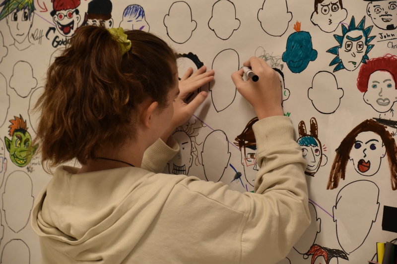 A Resilience Academy student stops to create her own face on the board.