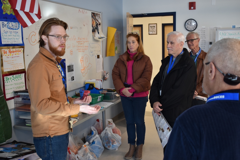 Board members speak with a teacher during a tour of the Resilience Academy