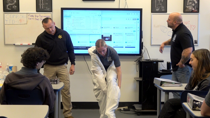 A student dons a Tyvek suit to experience what it's like during a demonstration from Dutchess County Sheriff's Office Crime Scene Unit detectives