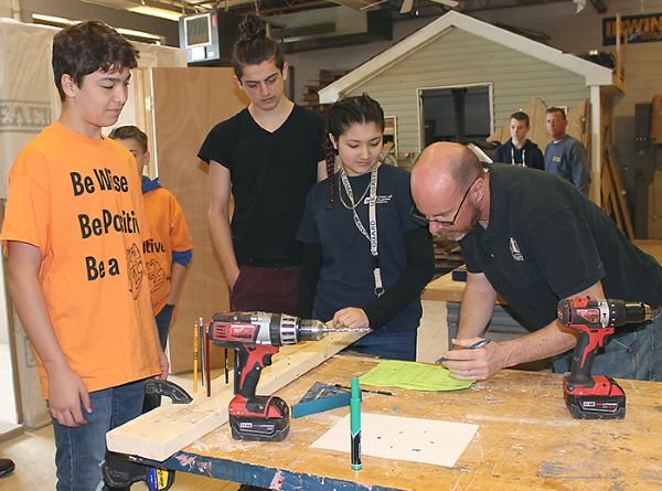 [PIC] Student Participant and CTI Judge Look Over Wood Working Excercise