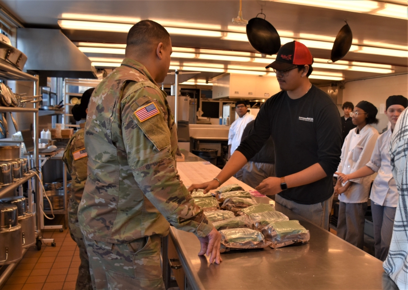 A student in the Culinary Arts and Restaurant Management program picks out an MRE to use in the challenge.