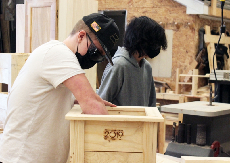 A student works on the inside of a planter.