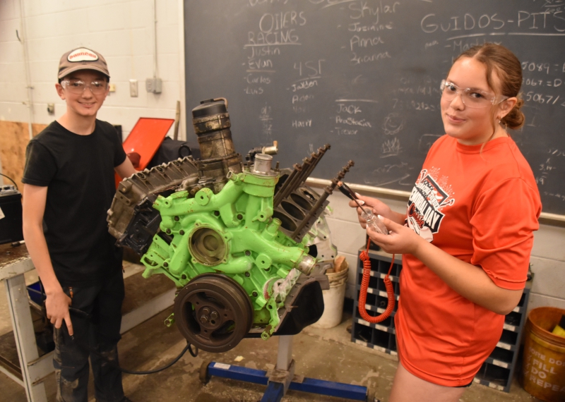 Middle school students Everett DiGiacomio and Ivy Dalbo ready to work on an engine in the automotive class at the Middle School Summer CTI Experience.