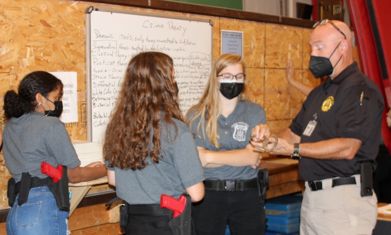 Photo of teacher Frank Kolarik demonstrating proper handcuffing technique to students