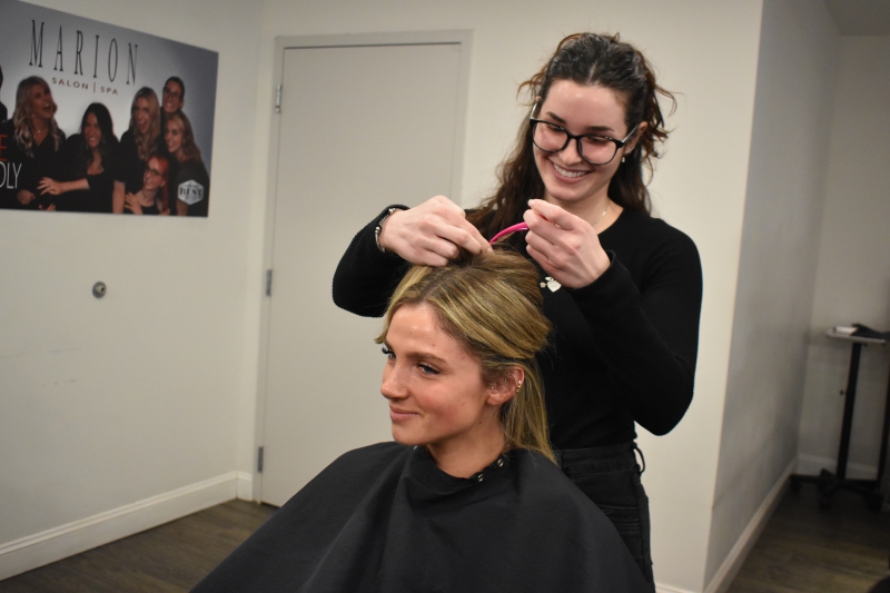 Jordyn-Alyse Duncan puts a client's hair up.