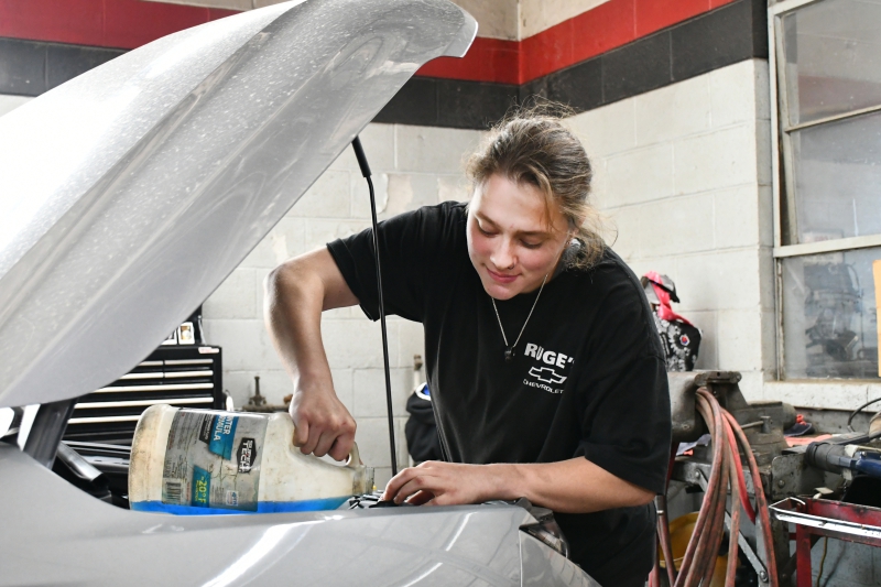 Scarlett Stoner adds windshield washer fluid to a vehicle at Ruge's Chevrolet.