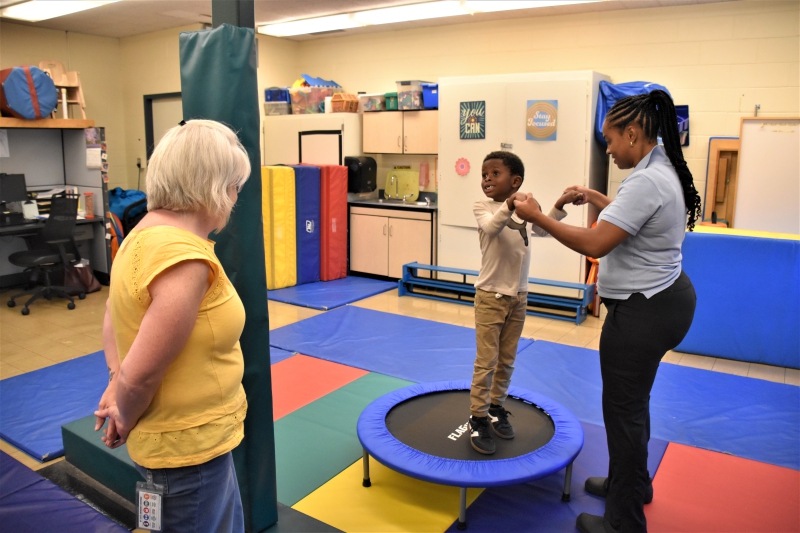 A student demonstrates the mini trampoline in the PT room.