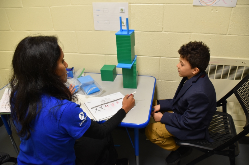 Ampact Tutor Darshana Stump goes over place values with SPC student Cameron Hartman.