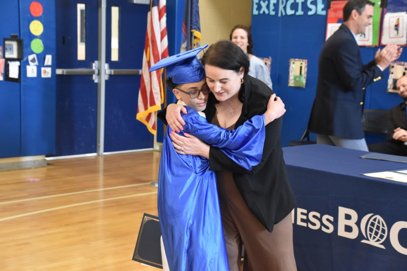 Student Kevin Redriguez hugs Salt Point Center Principal Melissa Murphy after receiving his certificate
