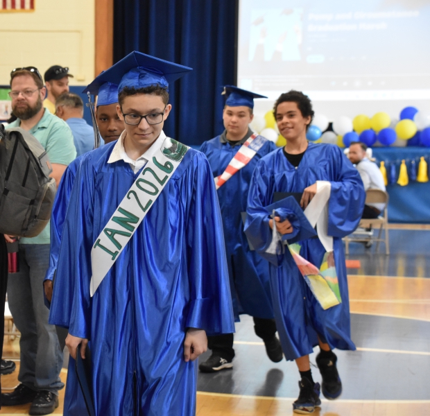 SPC Eighth graders in caps and gowns exit the Moving Up ceremony in a recessional.