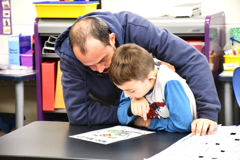 Stevie Beatty and his son, Stevie, look at the "Who Am I?" his son created in class.