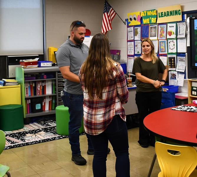 SPC Teacher Valerie Cantone speaks to two parents during Open House.