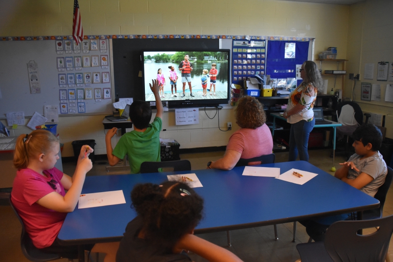 Students watch a video about water safety and life jackets in class.